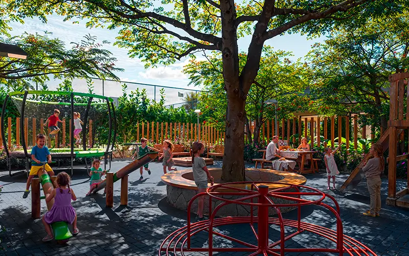 Playground do Villa Flamboyant com crianças brincando sob as árvores